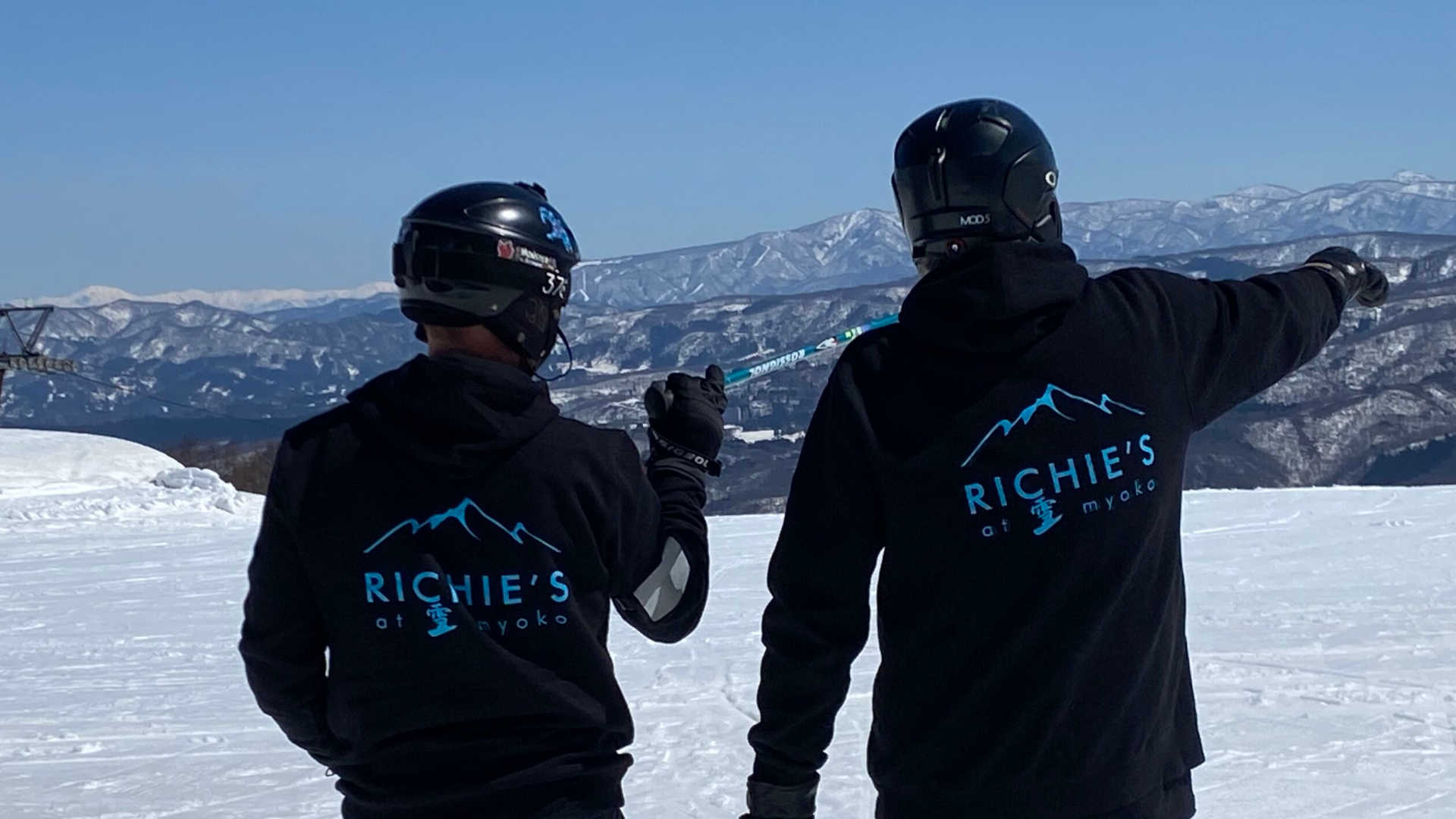 Two skiers wearing Richie's At Myoko jackets on the Japan ski fields near Myoko, Japan